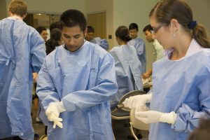 Medical students putting on gloves